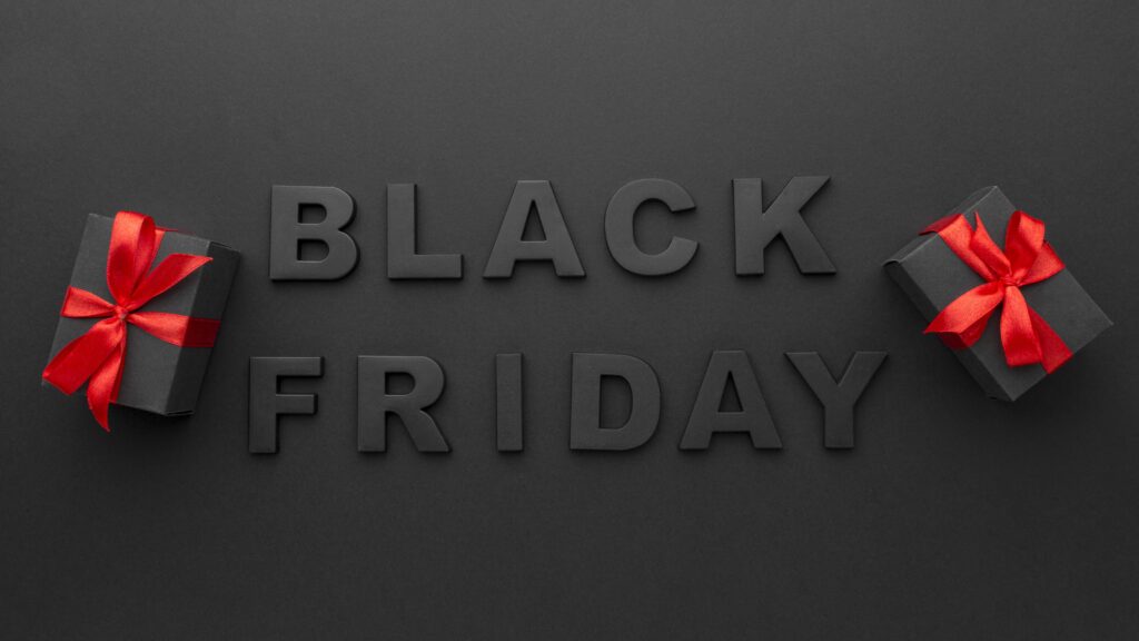 Black Friday online shopping scene with laptop and gift boxes tied with red ribbons