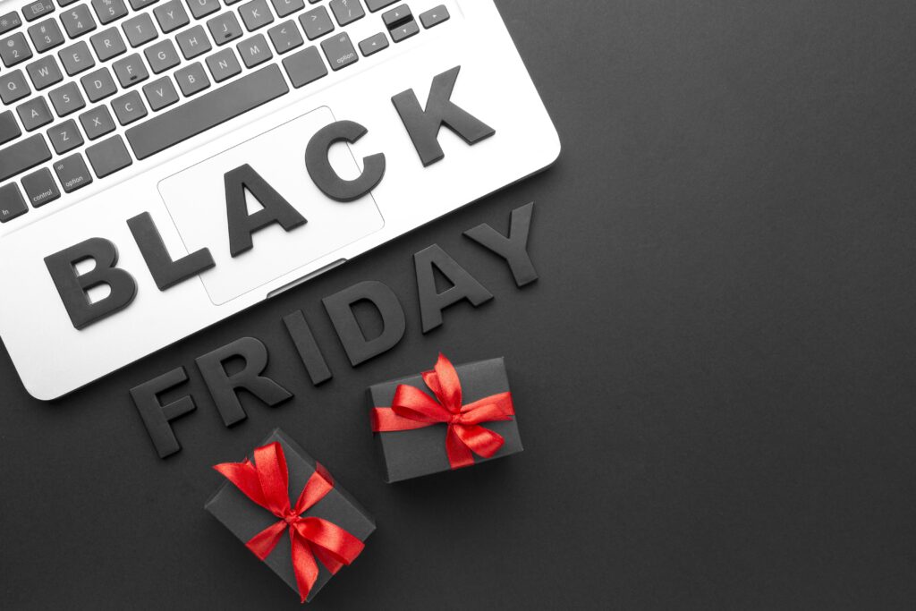 Black Friday online shopping scene with laptop and gift boxes tied with red ribbons